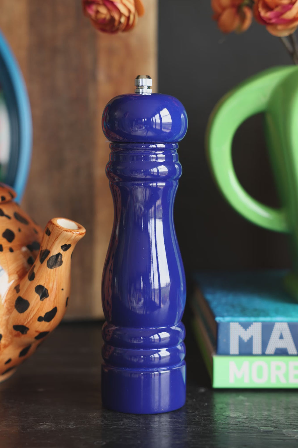 The Dark Blue Salt/Pepper Mill being removed from a dark surface with various accessories on.