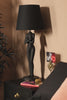 The Black Naked Lady Table Lamp switching on.