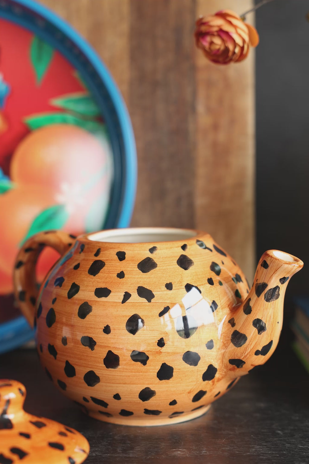 Some money being placed into the Painted Leopard Print Teapot.