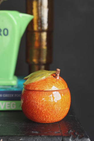 The lid being removed from the Orange Storage Jar and a spoon of sugar being taken from the inside.
