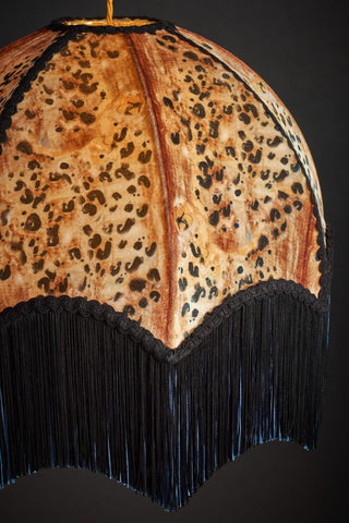 Close up image of  leopard print ceiling lamp with black fringing designed by Anna Hayman. 