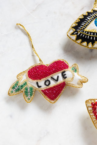 The Love Heart Beaded Hanging Christmas Tree Decoration styled with others on a white surface.