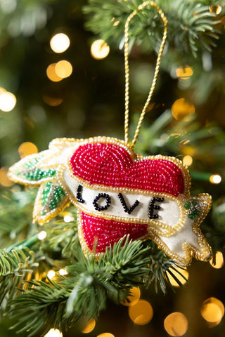 The Love Heart Beaded Hanging Christmas Tree Decoration styled hanging from the branch of a Christmas tree.