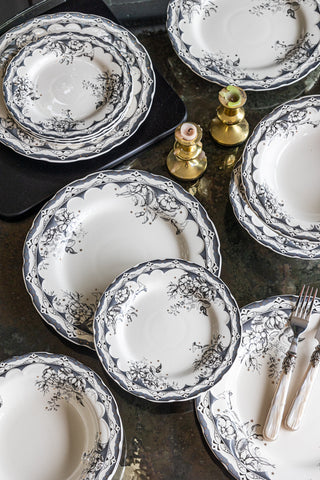The 12-Piece Vintage-Style Floral & Star Dinner Set displayed on a marble table, styled with cutlery, a serving board and gold candlesticks.