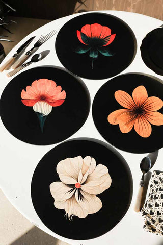 The Set Of 4 Beautiful Floral Placemats displayed on a white table with cutlery and a napkin.
