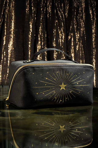 The After Party Makeup Bag Beauty Gift Set displayed on a dark surface in front of a metallic background.
