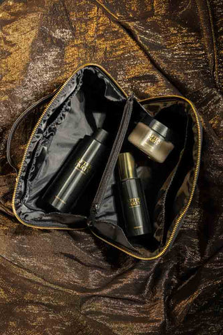The After Party Makeup Bag Beauty Gift Set, open and seen from above, on a metallic surface.