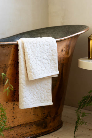 Leopard Jacquard Towel in Almond shown against a copper bath.