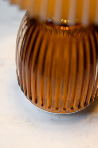 Close-up of the Amber Pleated Rechargeable Table Lamp on a white surface.