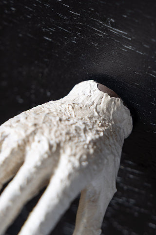 Close-up of a textured white hand handle against a black background.
