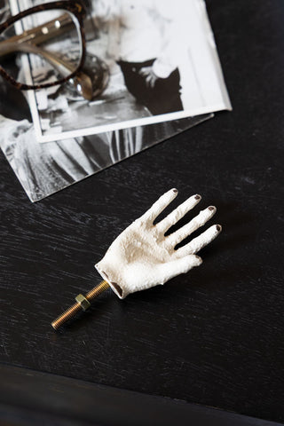 The Vintage-Style Hand Cupboard/Drawer Knob styled on a black surface with some glasses and photographs.