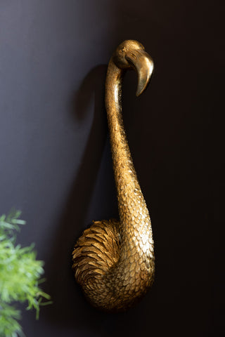 Image of the Antique Gold Flamingo Head Wall Art shown against a dark wall. 