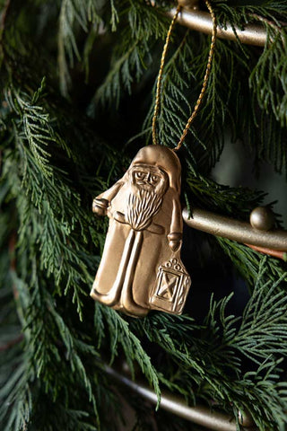Styled image of the Antique Gold Santa Christmas Tree Decoration on natural foliage