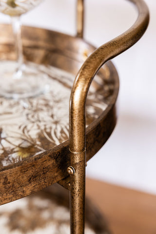 Close-up of a bar cart with glass shelves.