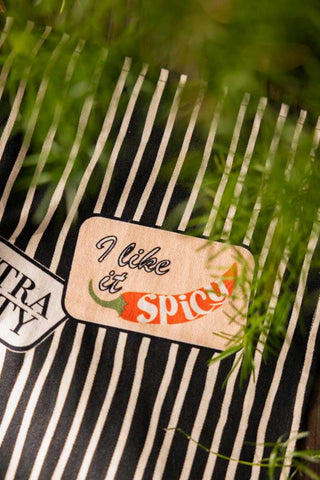 Close-up of the Badge Patch Tea Towel next to a plant.