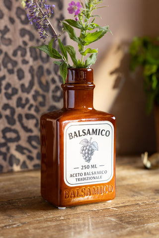 The Balsamico Ceramic Bottle Vase shown holding some wild flowers. 