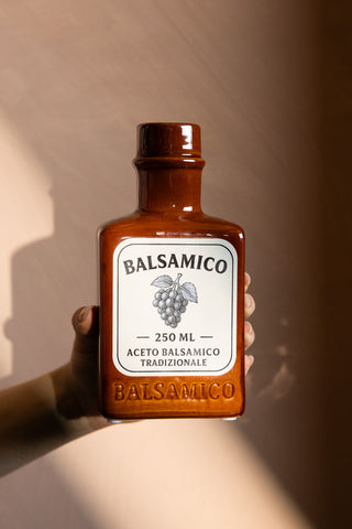 The Balsamico Ceramic Bottle Vase shown being held against a neutral backdrop. 