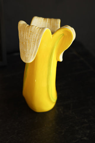 Detail image of the Banana Vase styled on a black sideboard. 