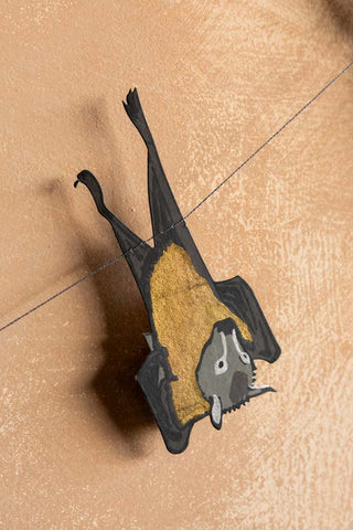 One of the bat designs hanging upside down on the Bats Sewn Paper Halloween Garland. 