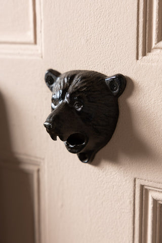The Bear Head Wall Mounted Bottle Opener shown mounted on a door. 