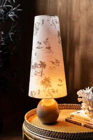 Lifestyle image of the Beautiful Desert Island Tapered Table Lamp Illuminated
