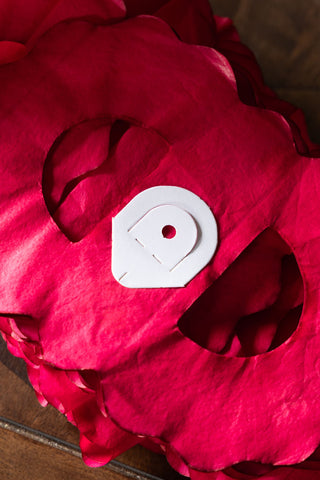 The end of the Beautiful Handcrafted Classic Paper Garland in Bright Red showing the paper hanging hook. 