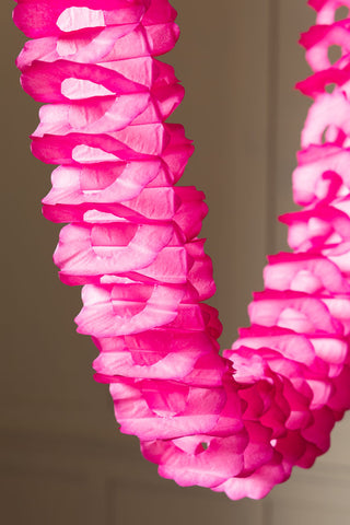 A close up showing the honeycomb pattern of the Beautiful Handcrafted Classic Paper Garland in Hot Pink as it is draped. 