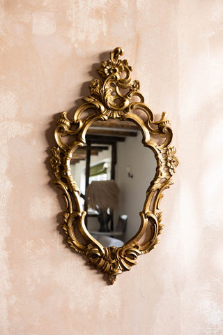 The Beautiful Ornate Gold Wall Mirror shown against a plaster wall. 