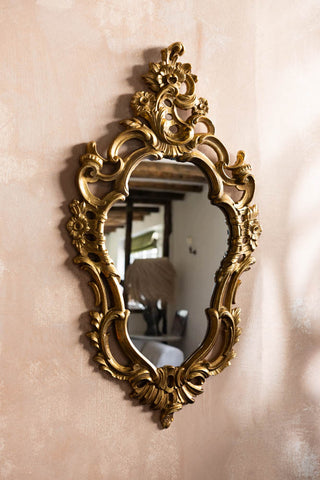 The Beautiful Ornate Gold Wall Mirror shown from the front on a plaster wall. 
