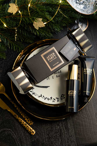 The After Party Hand & Body Beauty Cracker displayed with its contents on a Christmas table setting.