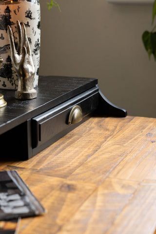 A close up image of the top of the desk and the one of the small top drawers on the Black Apothecary Desk With 3 Drawers.