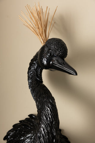 The Black & Gold Peacock Wall Art in front of a neutral wall.