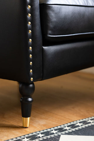 Close-up of the leg of the Black Faux Leather Chesterfield Armchair.