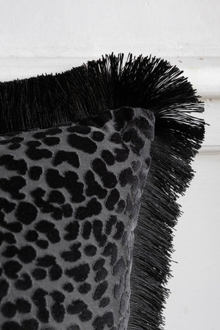 Close-up of the corner of the Black Leopard Velvet Cushion with Fringe Trim.
