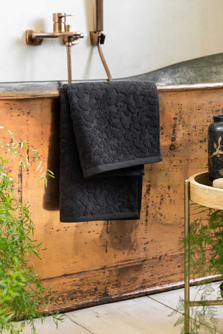 Leopard Jacquard Hand Towel styled against a copper bath. 