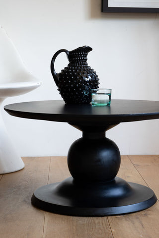 Lifestyle image of the Black Mango Wood Round Coffee Table