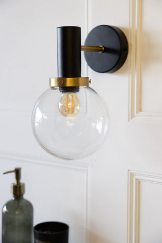 Lifestyle image of the Black & Brass Glass Outdoor Wall Light in a bathroom