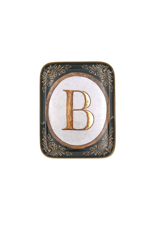 Cutout image of black and gold letter B tray on a white background. 