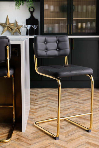 Lifestyle image of Black & Gold Faux Leather Retro Curve Bar Stool in a kitchen. 