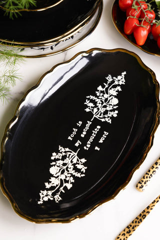 The Black & Gold Floral F Word Serving Platter displayed as part of a tablescape.
