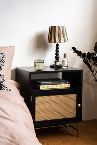 Lifestyle image of the Black & Gold Rattan Bedside Table