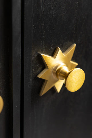 The gold star handle on the cupboard doors of the Black & Gold Ringo Shelving Unit. 