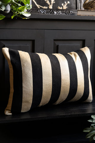 The Black & Gold Stripe Cushion Cover styled on a black bench. 