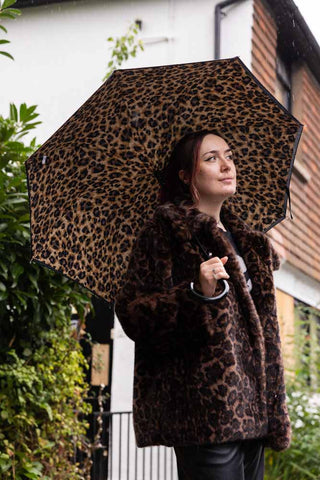 Black & Leopard Print Umbrella shown with a model wearing a leopard faux fur coat. 