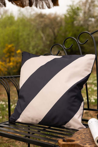 Lifestyle image of the Black & Natural Stripe Outdoor Cushion