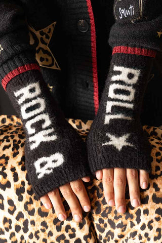 The Black & White Rock 'N' Roll Handwarmers being worn by a model with their hands resting on a leopard print chair.
