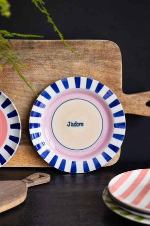 The Blue & Pink J’adore Ceramic Serving Plate leaning against a chopping board.