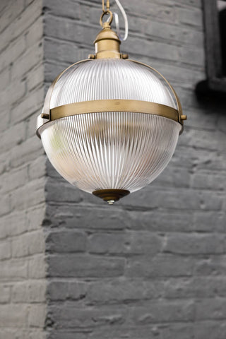 Image of the Boulevard Pendant Light outdoors in front of a grey brick wall.