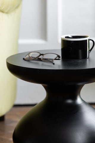 Closer image of the Bowl-Shaped Base Black Side Table in a bedroom