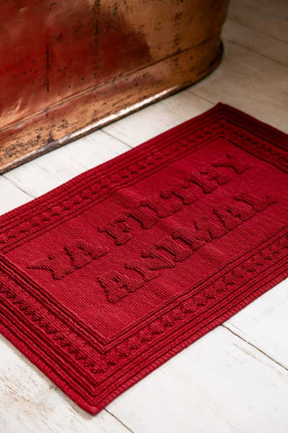 Image showing the Filthy Animal Cherry Red Bath Mat styled next to a copper bath. 